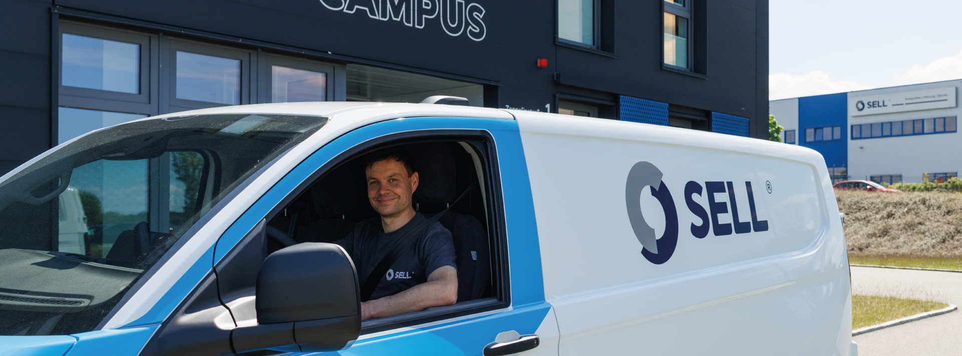 Firmenfahrzeug und Kollege vor dem Sell Campus